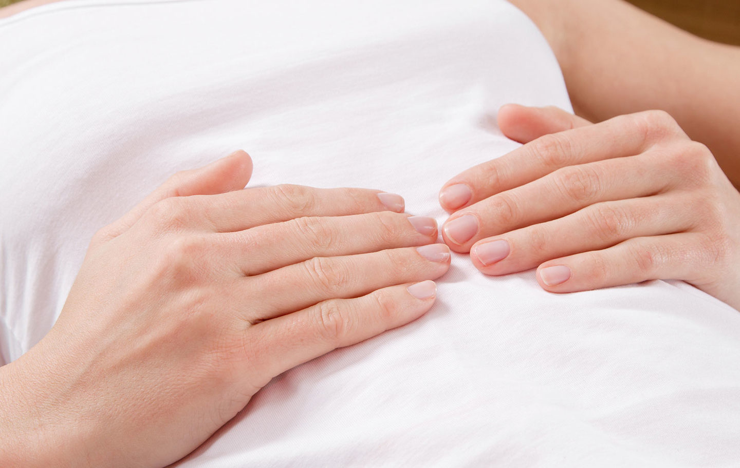 Hände auf einem Bauch — Assoziationsbild für Darmgeräusche und Verdauungsprozesse