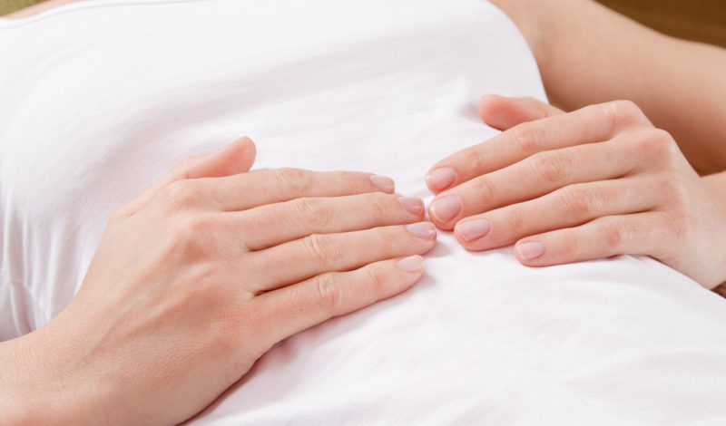 Hände auf einem Bauch — Assoziationsbild für Darmgeräusche und Verdauungsprozesse