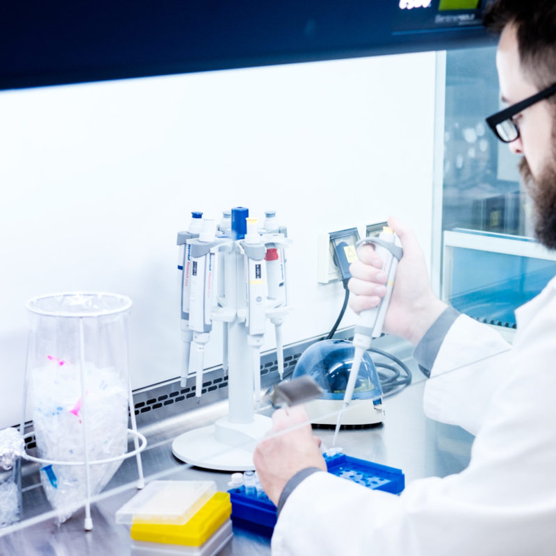 Laborforscher bei der Arbeit mit Pipetten und Laborausrüstung in einem modernen Forschungslabor. Die Szene zeigt präzise wissenschaftliche Tätigkeiten zur Analyse und Experimentierung.