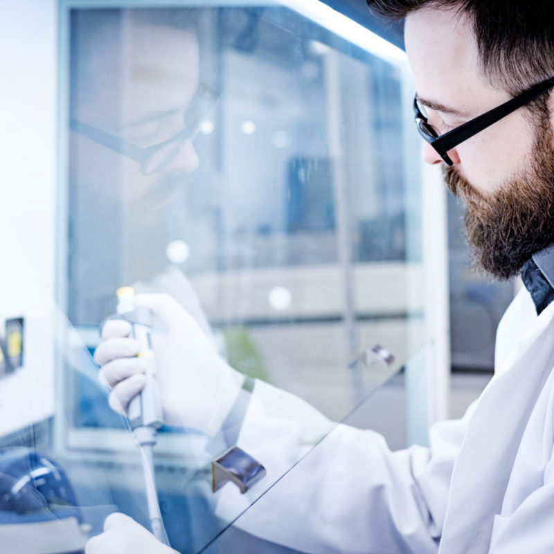 Wissenschaftler im Labor verwendet eine Pipette zur genauen Messung von Flüssigkeiten, um wissenschaftliche Experimente durchzuführen.