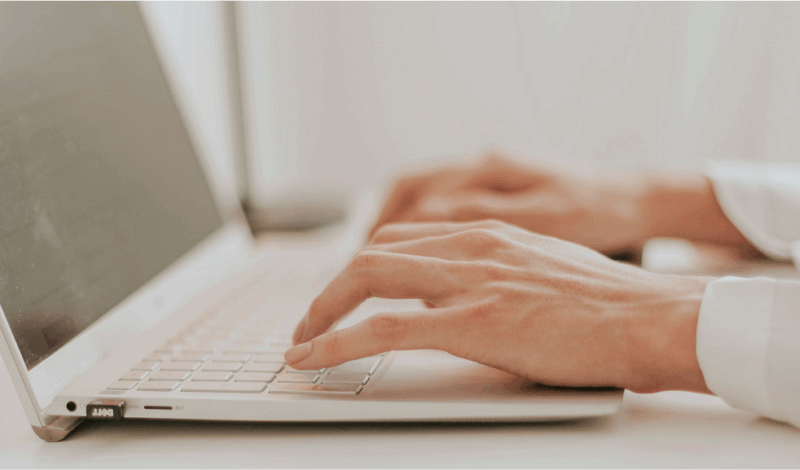 Nahaufnahme von Händen, die auf einer Laptop-Tastatur tippen, ideal für Themen wie Produktivität, Homeoffice und digitale Kommunikation.