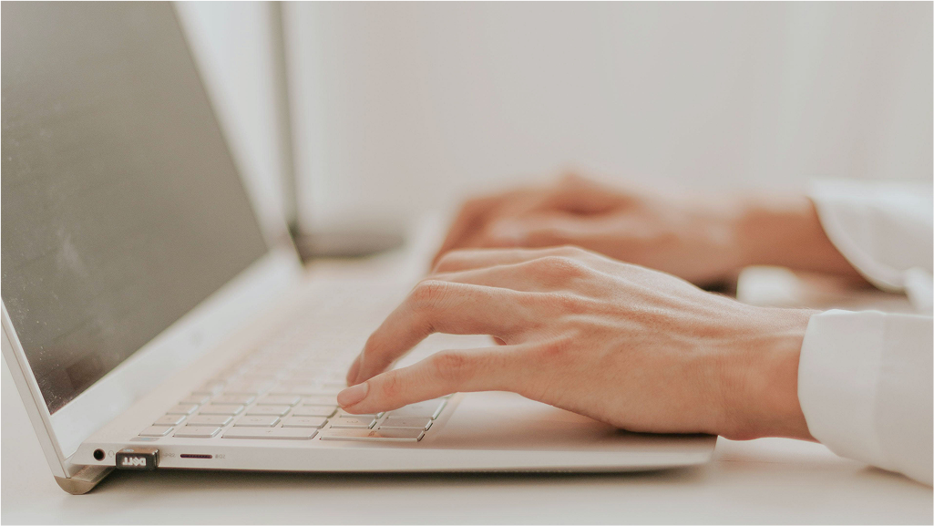Nahaufnahme von Händen, die auf einer Laptop-Tastatur tippen, ideal für Themen wie Produktivität, Homeoffice und digitale Kommunikation.